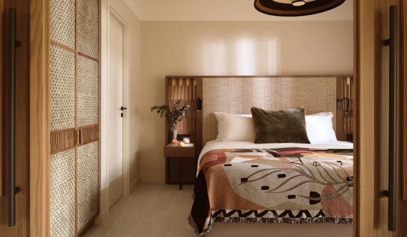 Deluxe Suite Garden View bedroom interior with natural wood accents, sliding woven wardrobe doors, and minimalist bedside decor at Eagles Palace by Kenwood Travel