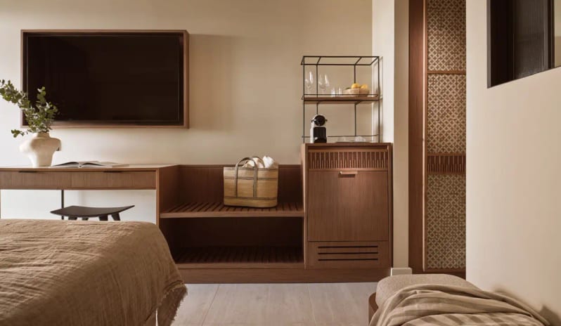 Deluxe Double Room Garden Viewwall-mounted TV, a minimalist wooden desk, and a built-in refreshment center with an espresso machine and glassware at Eagles Palace by Kenwood Travel