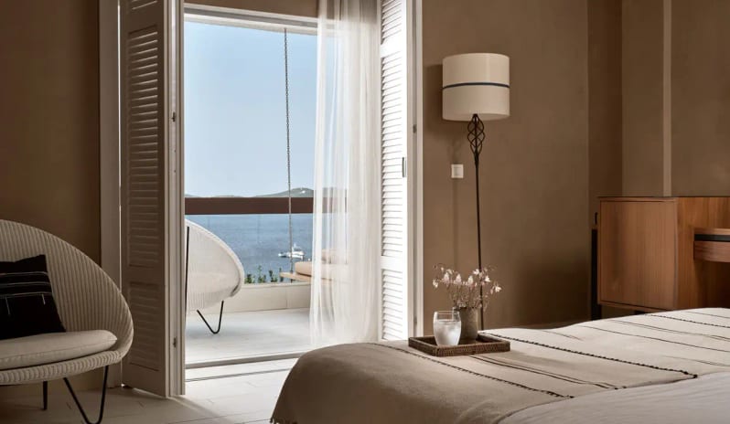Bungalow Sea View room with earthy tones, white shutters opening to a private terrace overlooking the Aegean Sea at Eagles Palace by Kenwood Travel