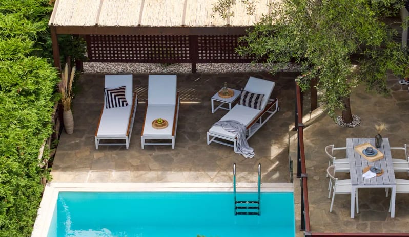 Two Bedroom Suite Garden View Private Pool sun loungers under a wooden gazebo and a fully set outdoor dining table surrounded by lush greenery at Eagles Palace by Kenwood Travel