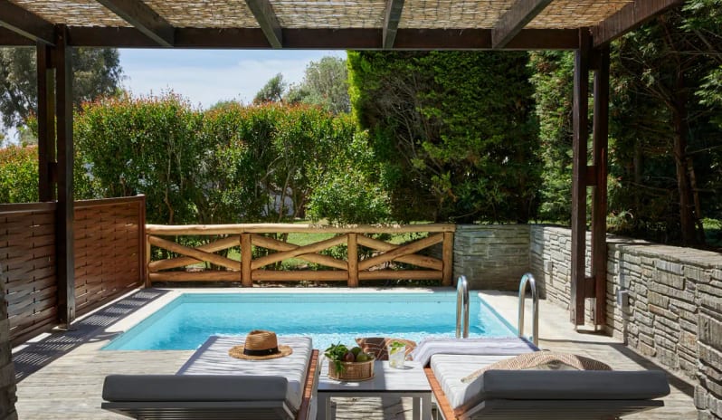 Two Bedroom Suite Garden View Private Pool rustic wooden fence and lush greenery, with sun loungers set up under a shaded wooden pergola at Eagles Palace by Kenwood Travel