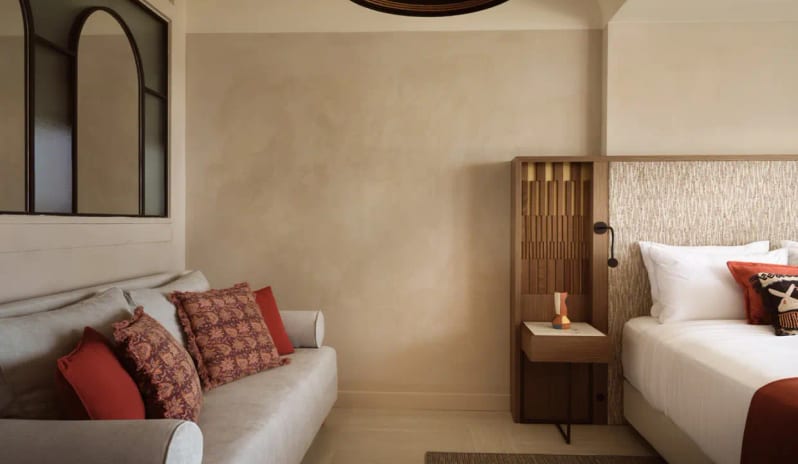 Deluxe Junior Suite Sea Front modern sofa with terracotta pillows and unique Mediterranean decor at Eagles Palace by Kenwood Travel