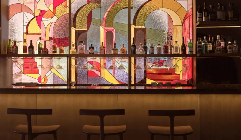 Eagles Club large vibrant stained glass mural backdrop with geometric arches and warm under-counter lighting at Eagles Villas by Kenwood Travel