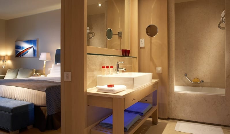 The Collection Premium Junior Suite with Private Pool king bed and an integrated marble bathroom featuring a vessel sink and soaking tub at Daios Cove by Kenwood Travel