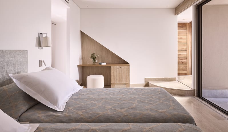 Olives & Sea Two Bedroom Suite Private Pool Harbour View/Sea View twin beds with luxury linens, a built-in wooden desk nook, and floor-to-ceiling glass doors at St.Nicolas Bay Resort by Kenwood Travel