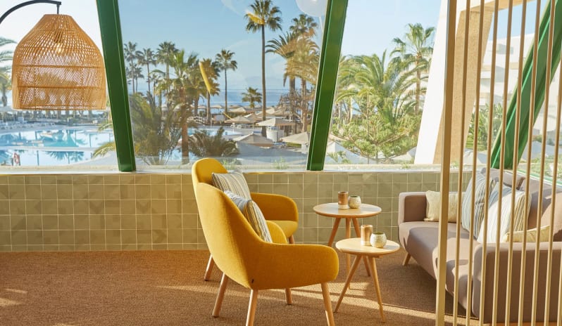 Coco Cafe showcasing comfortable modern furniture and expansive views of the resort pool and palm gardens at Dreams Lanzarote Playa Dorada Resort & Spa by Kenwood Travel