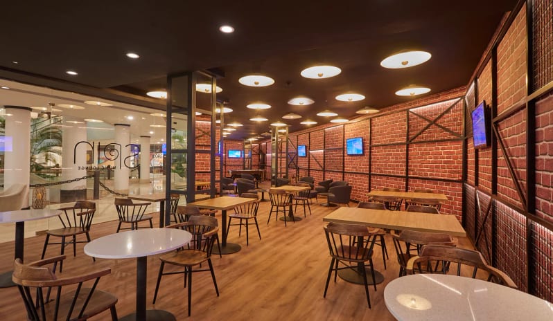 Spin Music Lounge & Half Time Sports Bar A blue felt billiard table with a rack of pool balls in a modern lounge featuring wood floors, bar stools, and an industrial brick wall design at Dreams Lanzarote Playa Dorada Resort & Spa by Kenwood Travel