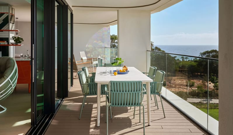 Supreme Three-Bedroom Residence Luxury hotel terrace with outdoor dining furniture, glass railings for an unobstructed sea view, and contemporary architectural design at W Algarve by Kenwood Travel