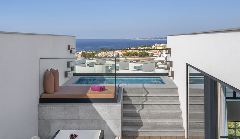 W Suite with Plunge Pool, One Bedroom Suite rooftop plunge pool with a glass safety railing, featuring a sunbed with plush cushions and stone steps leading to an elevated terrace with panoramic ocean and coastal town views at W Algarve by Kenwood Travel