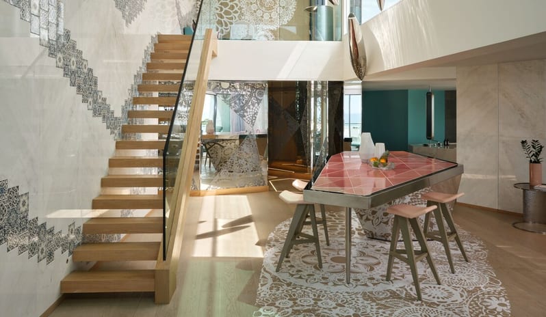 Penthouse II Suite, One Bedroom Suite with Pool light wood staircase with glass railings, patterned marble walls, and a modern pink tiled kitchen island with bar stools at W Algarve by Kenwood Travel