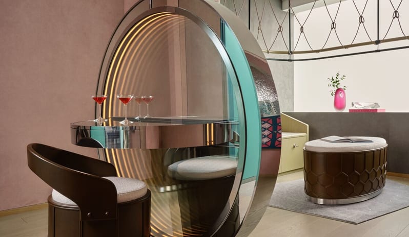 Penthouse II Suite, One Bedroom Suite with Pool featuring a circular infinity mirror vanity with integrated lighting, a sleek dark wood chair, and a leather upholstered ottoman at W Algarve by Kenwood Travel