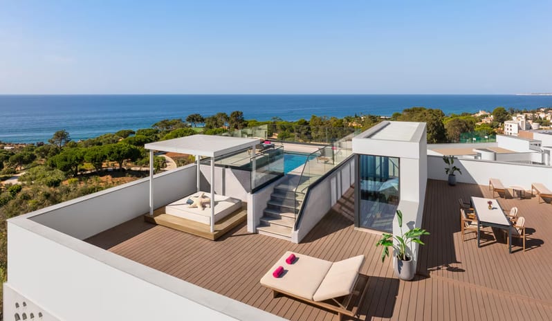 Penthouse I, Two Bedroom Suite with Pool Private rooftop featuring a wooden deck, a private glass-walled swimming pool, a cabana daybed, sun loungers, and an outdoor dining area overlooking the ocean at W Algarve by Kenwood Travel
