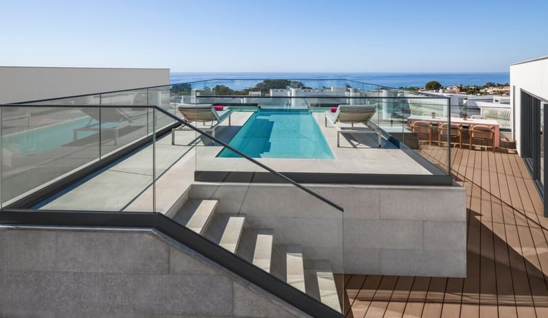 Penthouse II Suite, One Bedroom Suite with Pool rooftop featuring a narrow rectangular lap pool with glass railings, two sun loungers, and an outdoor dining area overlooking the ocean at W Algarve by Kenwood Travel