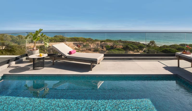 Penthouse I, Two Bedroom Suite with Pool Private rooftop plunge pool with sparkling blue tiles, featuring a modern sun lounger with a pink towel on a stone terrace overlooking the ocean and coastal cliffs at W Algarve by Kenwood Travel
