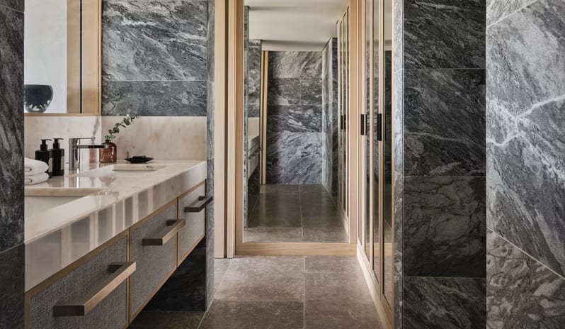 Supreme Two Bedroom Suite bathroom and dressing area featuring dark grey marble walls and a cream marble double vanity with textured grey drawers at W Algarve by Kenwood Travel