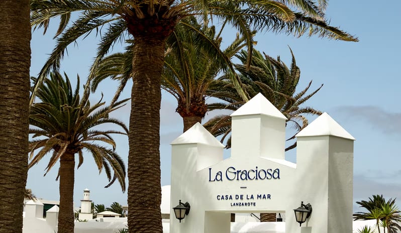 La Graciosa Restaurant archway entrance of La Graciosa Casa de la Mar in Lanzarote, surrounded by palm trees under a clear blue sky at Paradisus Salinas Lanzarote by Kenwood Travel
