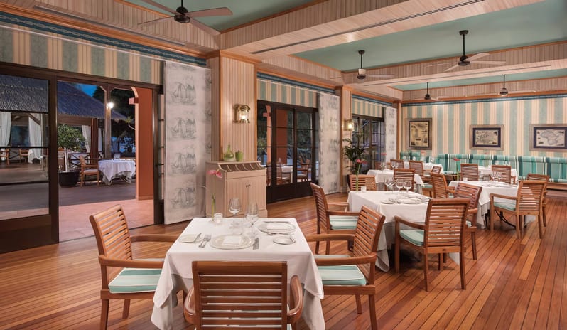 El Faro Restaurant nautical-themed dining room featuring polished wood floors, striped wallpaper, and teak wood chairs with light blue cushions around tables set with white linens at Sheraton Fuerteventura Beach, Golf & Spa Resort by Kenwood Travel