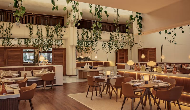 Samira restaurant interior at a luxury resort featuring cognac leather armchairs, wooden dining tables, and long banquettes at Paradisus Salinas Lanzarote by Kenwood Travel