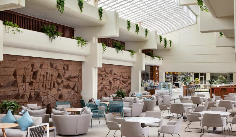Ginger Lobby Bar with a glass grid ceiling, featuring textured red stone relief walls, indoor hanging plants at Paradisus Salinas Lanzarote by Kenwood Travel