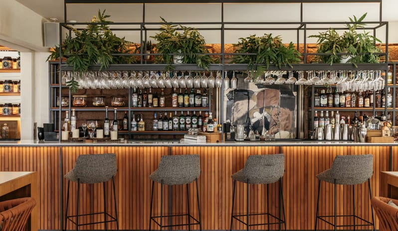 Ginger Lobby Bar cocktail bar with a vertical wood-slat base, grey upholstered bar stools at Paradisus Salinas Lanzarote by Kenwood Travel