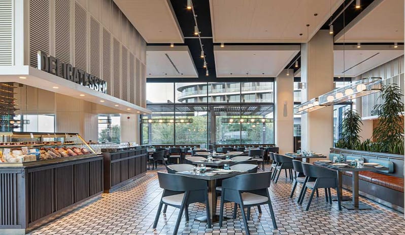 Cuisine24 featuring a delicatessen counter, elegant seating, and floor-to-ceiling windows at Voyage Belek Golf & Spa by Kenwood Travel