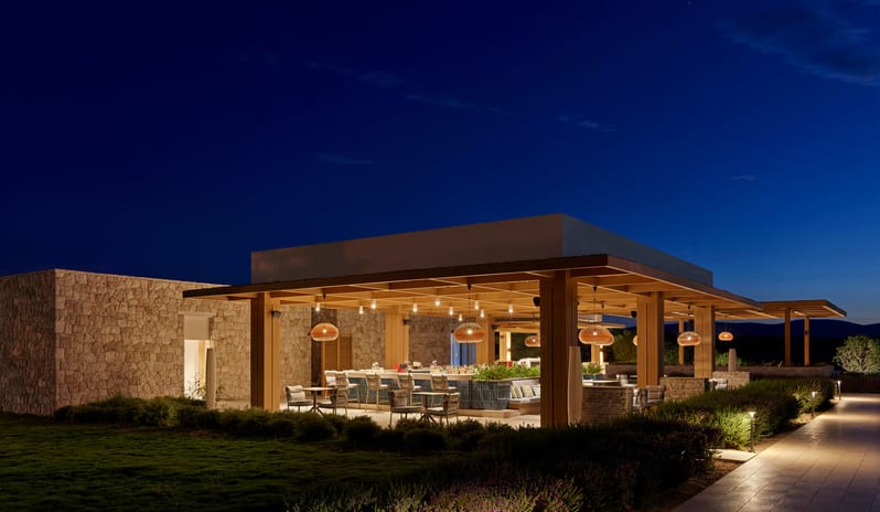 Adult Pool Bar Contemporary open-air pavilion architecture with stone masonry and integrated landscape lighting at Anda Barut Collection by Kenwood Travel