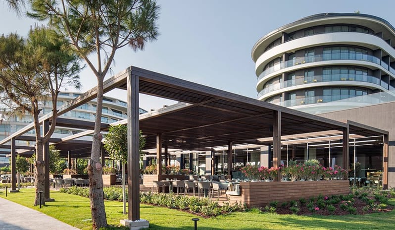 Degusto Main Restaurant Exterior view of the Degusto Main Restaurant terrace at Voyage Belek resort with contemporary architecture and garden landscaping at Voyage Belek Golf & Spa by Kenwood Travel