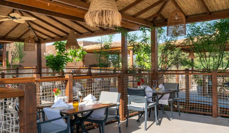 Balbura Grill Restaurant wooden rustic architecture, woven pendant lights, and set tables with views of greenery at Liberty Fabay by Kenwood Travel