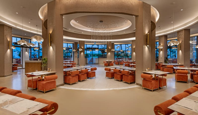 Timeless 7/24 A’la Carte Restaurant a grand circular architectural center, modern terracotta velvet seating, and elegant pendant lighting at Liberty Signa Hotel by Kenwood Travel