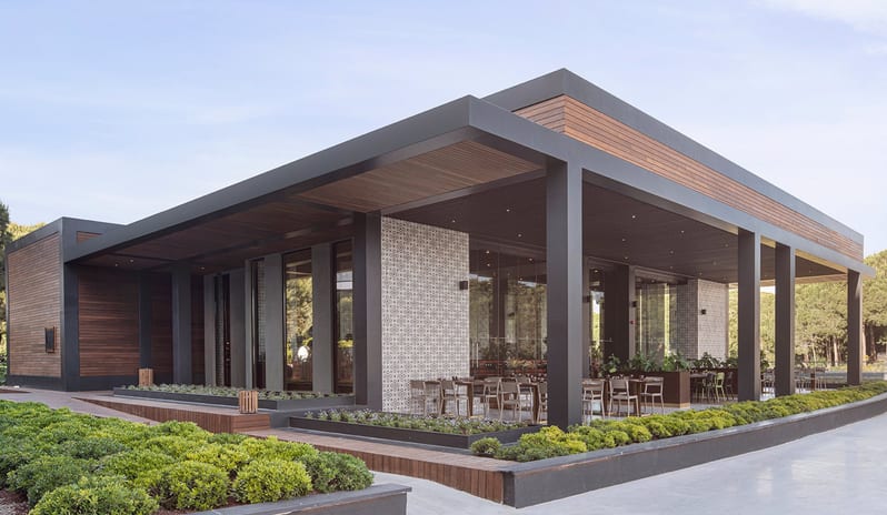 Carino Steak Restaurant featuring wood paneling, patterned tile walls, and outdoor seating at Voyage Belek Golf & Spa by Kenwood Travel
