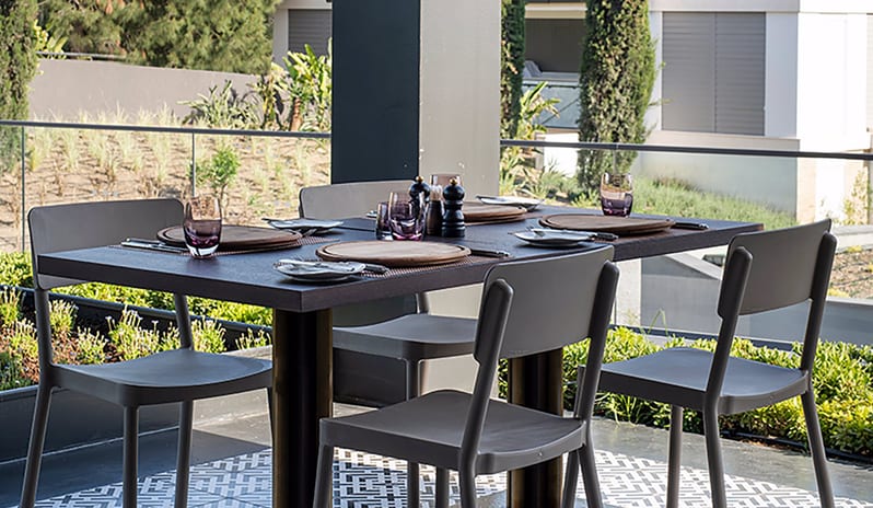 Carino Steak Restaurant modern table setting on an outdoor terrace with garden views at Voyage Belek Golf & Spa by Kenwood Travel
