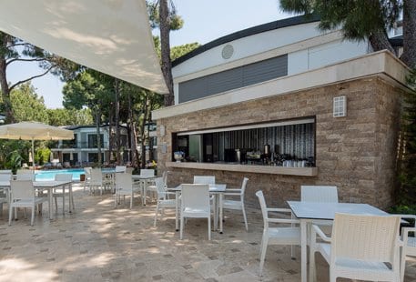 Lagoon Bar with white seating and stone masonry at Voyage Belek Golf & Spa by Kenwood Travel