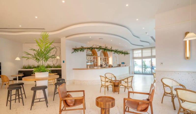 Araxa Adults Only Bar curved ceilings, terrazzo flooring, and minimalist wooden furniture with indoor greenery at Liberty Fabay by Kenwood Travel