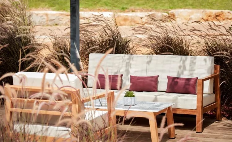 Shore wooden outdoor lounge furniture with white cushions and burgundy pillows at Tivoli Alvor Algarve by Kenwood Travel