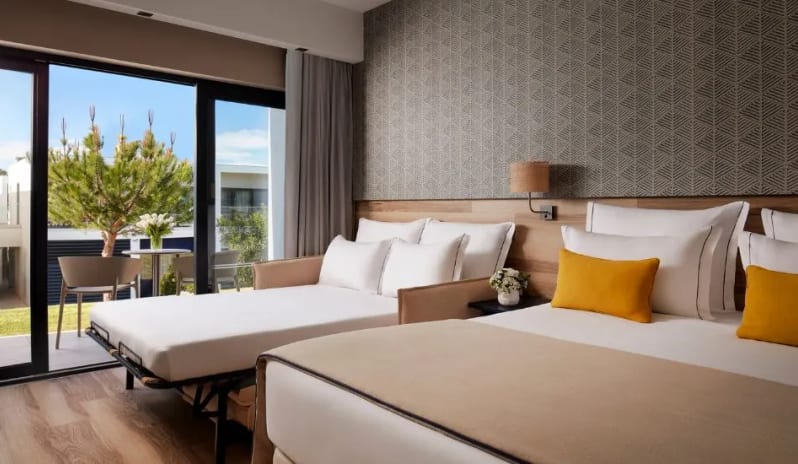 Family Room king large bed with yellow cushions and an adjacent open sofa bed, ideal for families, with a balcony view at Tivoli Alvor Algarve by Kenwood Travel