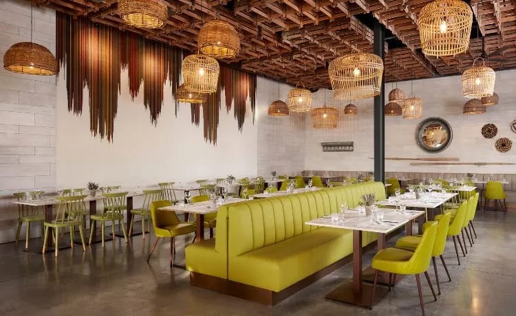 Essenze lime green booth seating, woven basket pendant lights, and a modern rustic wooden ceiling at Tivoli Alvor Algarve by Kenwood Travel