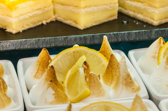 Buffet Principal Menurka lemon meringue tarts with toasted peaks and fresh lemon slices served alongside layered citrus cream cakes at a dessert buffet at Insotel Punta Prima Resort & Spa by Kenwood Travel