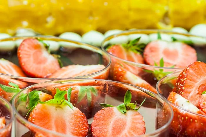 Sa Sivina Restaurant Close-up of gourmet strawberry desserts in glass cups with a yellow glazed cake in the background at Insotel Punta Prima Resort & Spa by Kenwood Travel