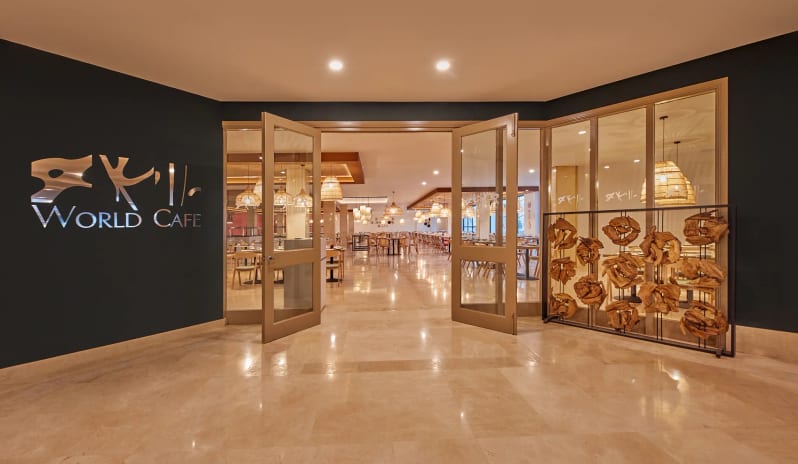 World Cafe polished marble floors, open glass doors, and a warm, spacious dining area with decorative pendant lighting at Dreams Lanzarote Playa Dorada Resort & Spa by Kenwood Travel