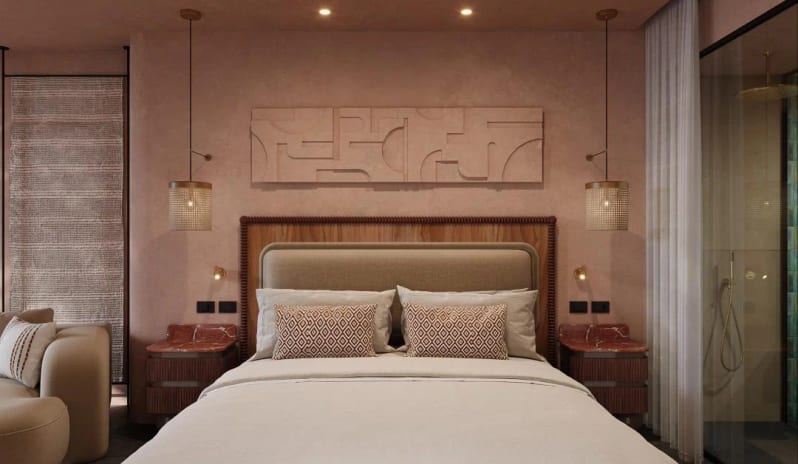 Deluxe Sea View king-sized bed flanked by marble-top bedside tables and mesh pendant lamps, featuring a large 3D geometric wall sculpture above the headboard at Costa Ragusa Borgo & Resort by Kenwood Travel