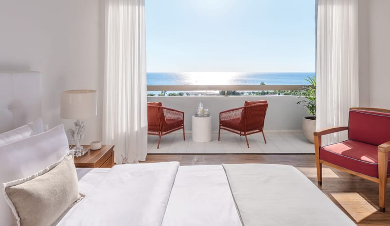 LUX ME Sea View Guestroom Modern luxury beach resort guestroom with floor-to-ceiling windows overlooking the Mediterranean Sea in Rhodes at Grecotel LUXME Dama Dama by Kenwood Travel
