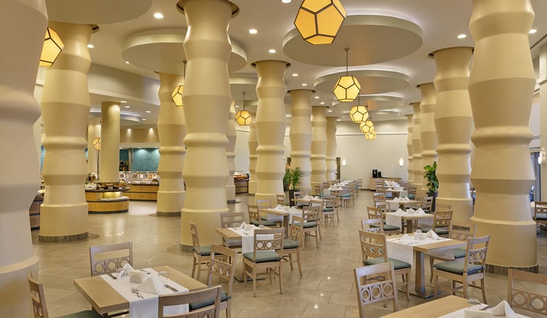 Main Restaurant Spacious hotel buffet restaurant featuring large cream-colored sculptural columns and geometric pendant lighting at Xanadu Island by Kenwood Travel