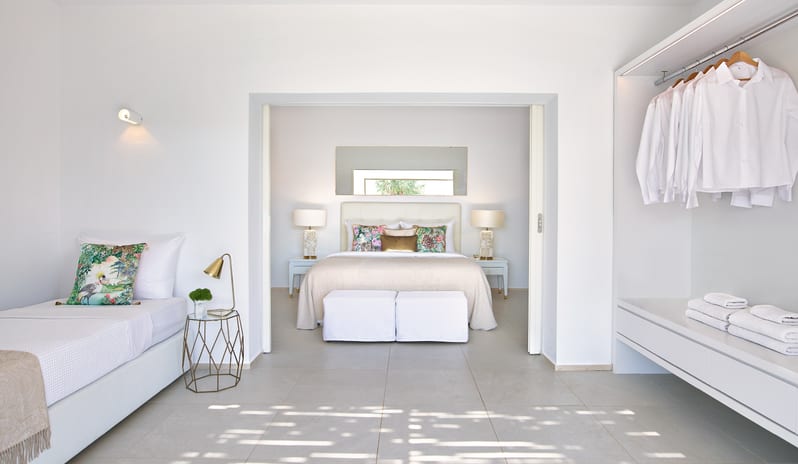 LUX ME Bungalow Poolside Luxury resort suite interior with minimalist white decor, open closet, and garden view bedroom at Grecotel LUXME Dama Dama by Kenwood Travel
