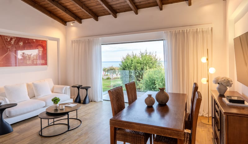 Two Bedroom Bungalow Suite Sea View wooden dining set, vaulted ceilings, large artwork, and a balcony with a sea view at Grecotel LUXME Dama Dama by Kenwood Travel