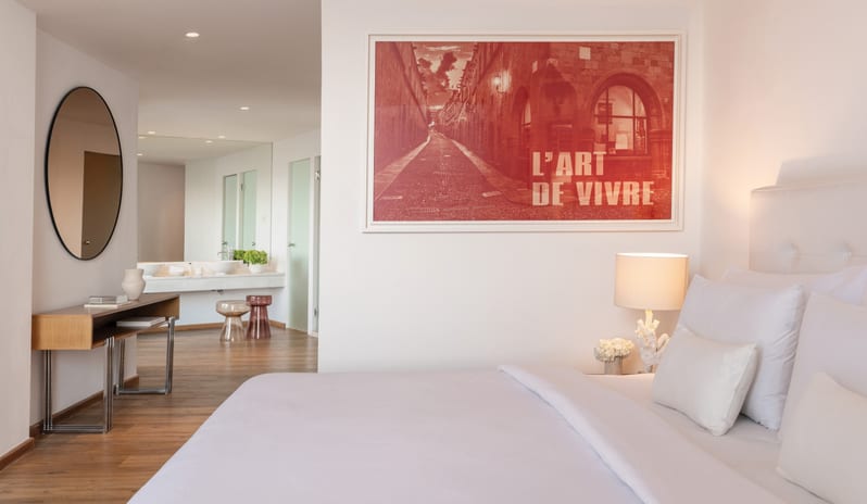 LUX ME Superior Guestroom Sea View wfeaturing 'L'Art de Vivre' wall art and a sleek vanity area at Grecotel LUXME Dama Dama by Kenwood Travel