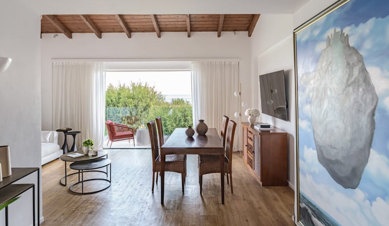 Two Bedroom Bungalow Suite Sea View wooden dining set, vaulted ceilings, large artwork, and a balcony with a sea view at Grecotel LUXME Dama Dama by Kenwood Travel
