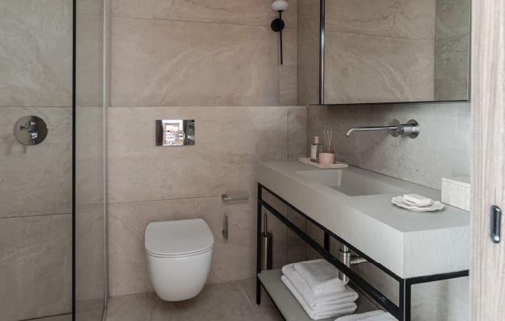 Premier Loft Family Guestroom contemporary hotel bathroom with beige stone-textured walls and floor at Grecotel LUXME Dama Dama by Kenwood Travel