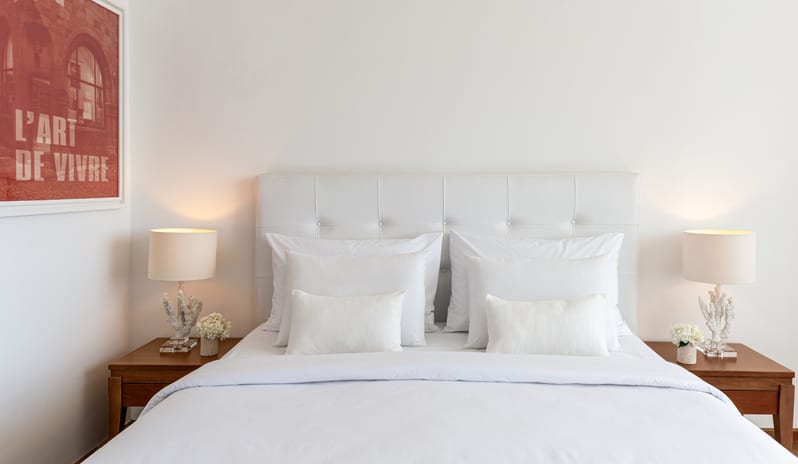 LUX ME Superior Guestroom Sea View white tufted headboard and coral-inspired bedside lamps at Grecotel LUXME Dama Dama by Kenwood Travel