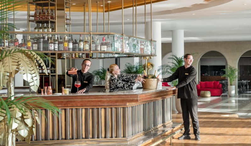 Lobby Bar Professional staff preparing cocktails and serving champagne at the elegant, modern lobby bar at Grecotel LUXME Dama Dama by Kenwood Travel
