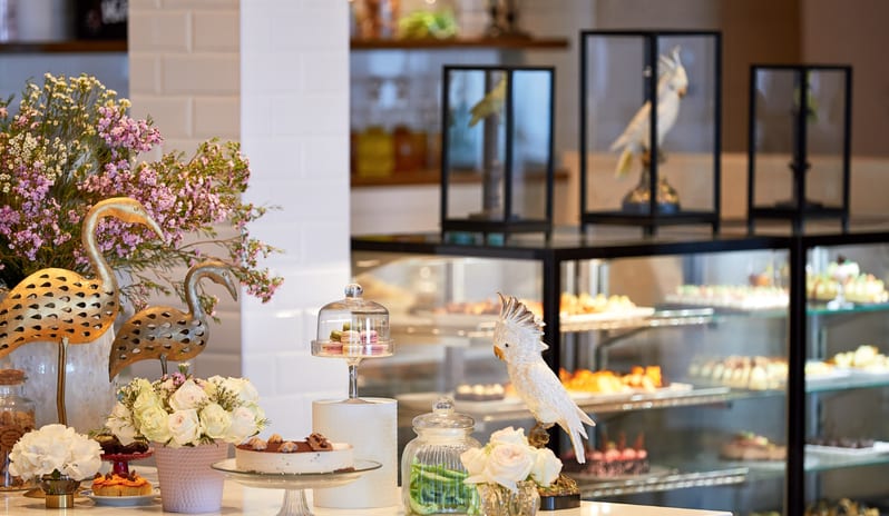 Patisserie & Chocolaterie Display of luxury desserts and floral arrangements at Grecotel LUXME Dama Dama by Kenwood Travel